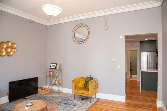 living area featuring hardwood / wood-style floors and ornamental molding