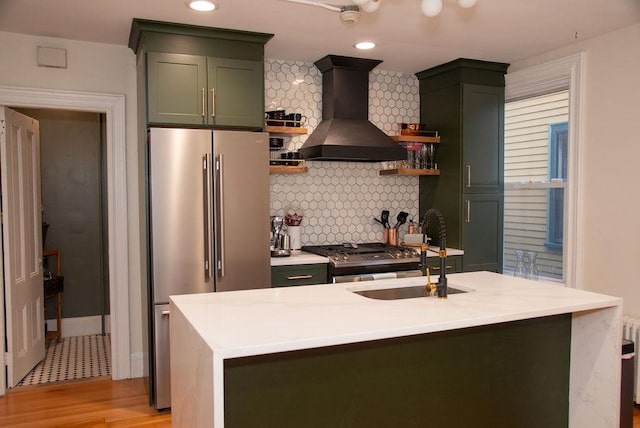 kitchen with premium range hood, sink, tasteful backsplash, green cabinets, and stainless steel appliances