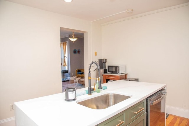 kitchen with green cabinets, dishwasher, sink, and light wood-type flooring