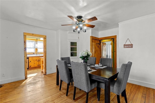 dining room with ornamental molding, ceiling fan, and light wood-type flooring