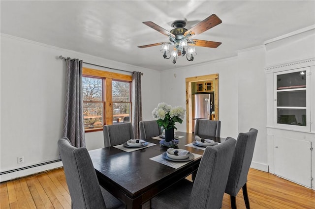 dining room with baseboard heating, ceiling fan, crown molding, and light hardwood / wood-style flooring