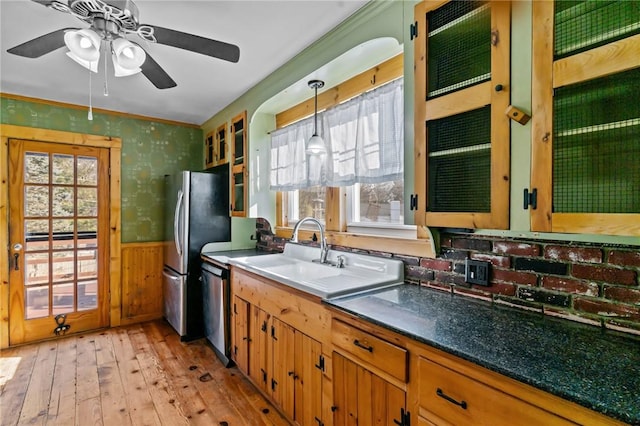 kitchen with appliances with stainless steel finishes, pendant lighting, ceiling fan, crown molding, and light hardwood / wood-style flooring