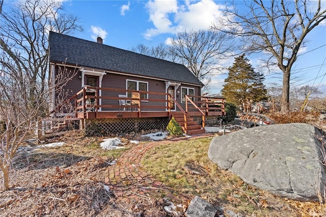 rear view of property featuring a wooden deck