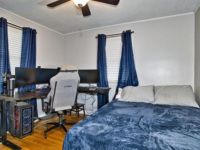 bedroom featuring crown molding, wood-type flooring, and a textured ceiling