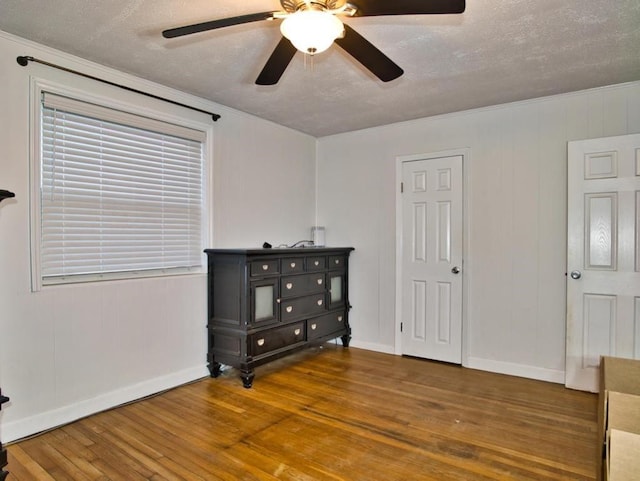 bedroom with ceiling fan, wood-type flooring, and a textured ceiling