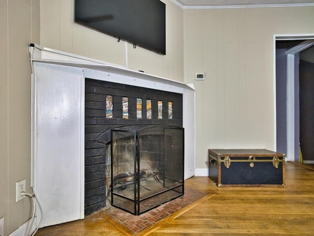 interior details with crown molding, a brick fireplace, and hardwood / wood-style flooring