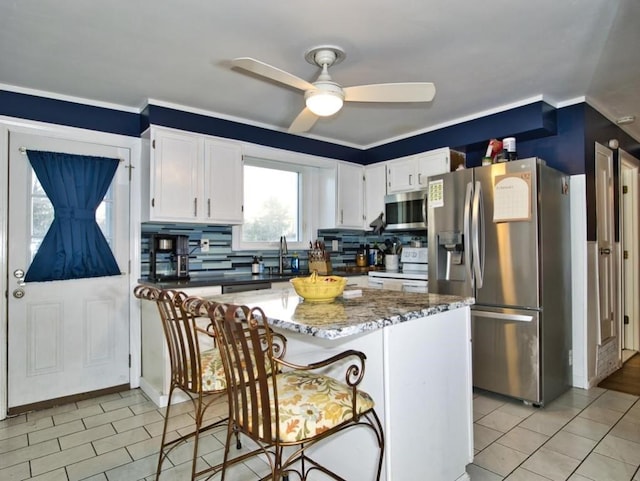 kitchen featuring light tile patterned floors, dark stone countertops, backsplash, stainless steel appliances, and white cabinets