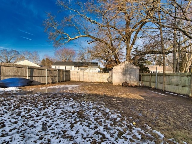 yard layered in snow featuring a storage unit