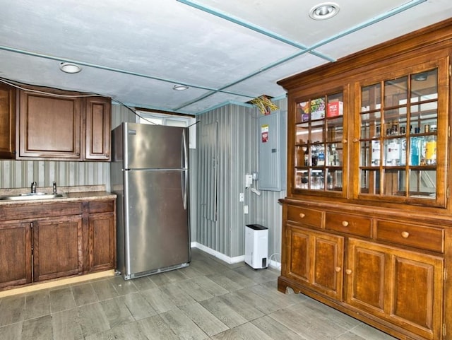 kitchen featuring sink, electric panel, and stainless steel refrigerator