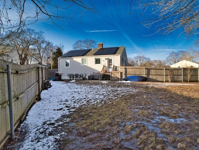 snow covered property featuring solar panels