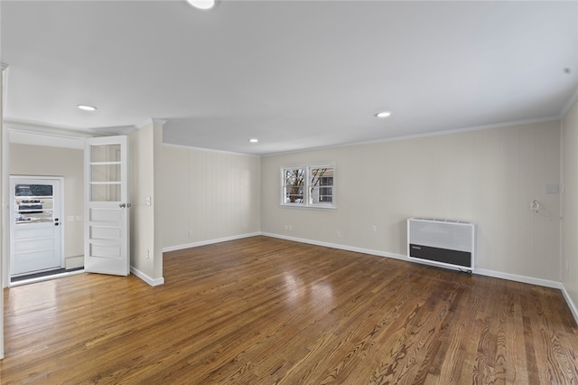 unfurnished living room featuring hardwood / wood-style flooring, crown molding, and heating unit