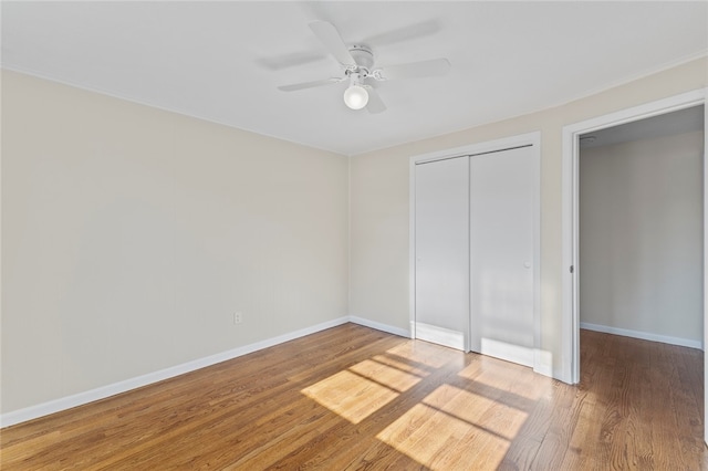 unfurnished bedroom featuring wood-type flooring, ceiling fan, and a closet