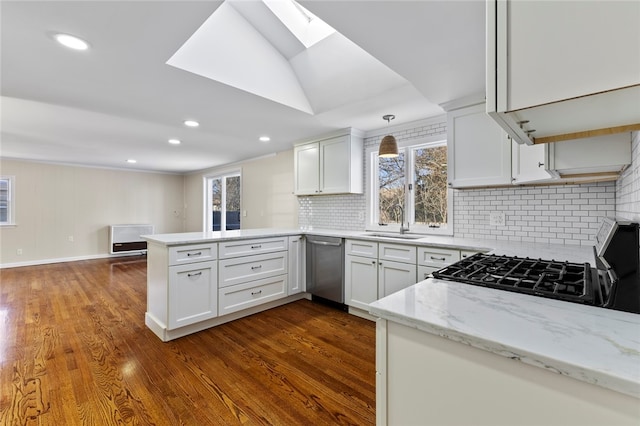 kitchen with decorative light fixtures, kitchen peninsula, and white cabinets