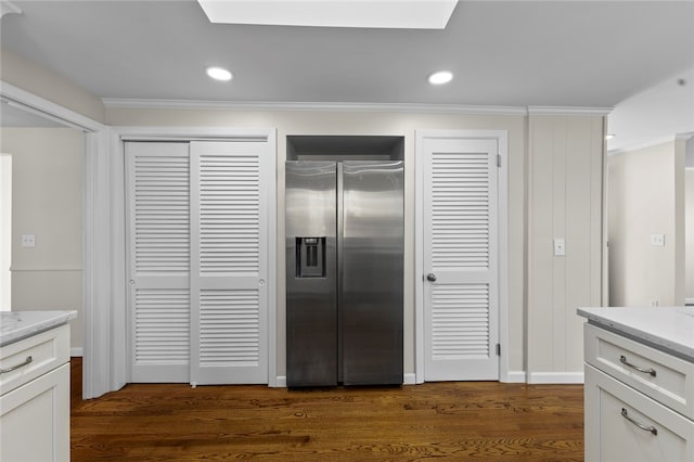 kitchen featuring white cabinets, crown molding, stainless steel fridge, and dark hardwood / wood-style flooring