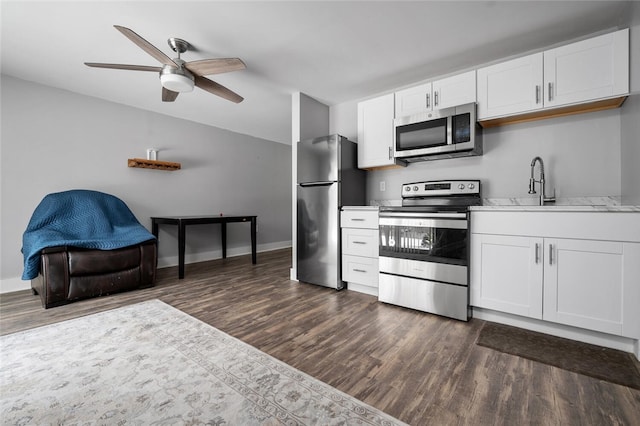 kitchen with sink, dark wood-type flooring, stainless steel appliances, and white cabinets