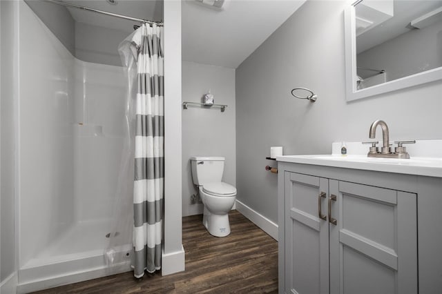 bathroom with hardwood / wood-style flooring, vanity, a shower with curtain, and toilet