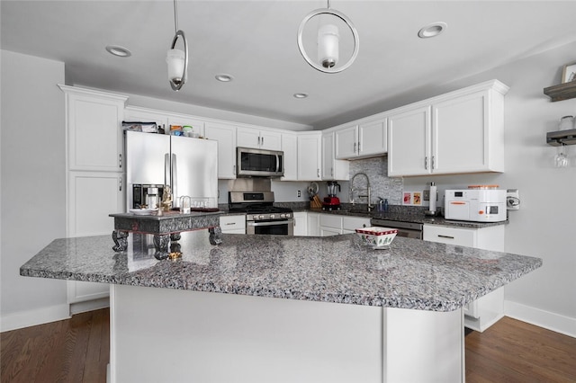 kitchen featuring appliances with stainless steel finishes, sink, dark wood-type flooring, and white cabinets