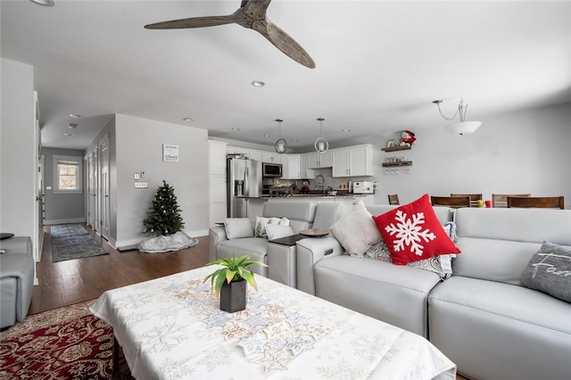 living room featuring ceiling fan, dark hardwood / wood-style floors, and sink