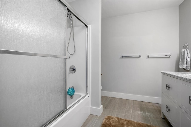 bathroom with vanity, wood-type flooring, and enclosed tub / shower combo