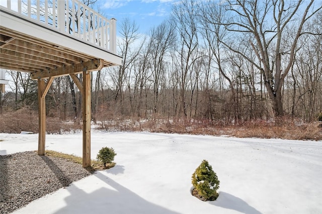 yard layered in snow featuring a deck