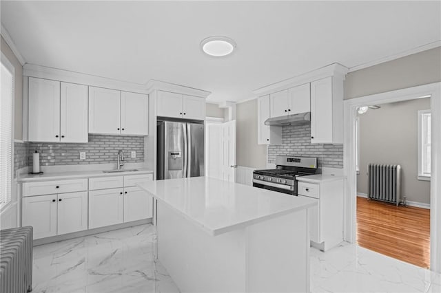 kitchen featuring white cabinetry, radiator heating unit, a center island, and appliances with stainless steel finishes