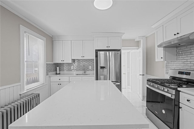 kitchen featuring stainless steel appliances, white cabinetry, sink, and radiator heating unit