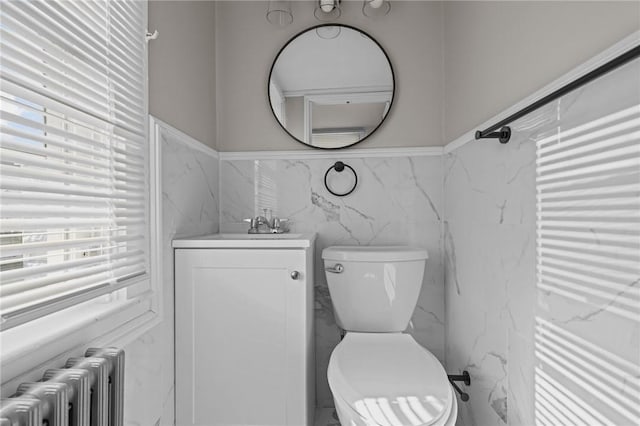 bathroom with vanity, radiator, and toilet