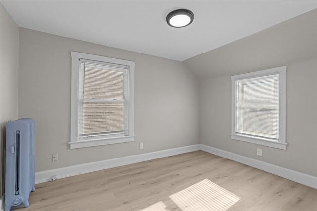 bonus room featuring radiator, vaulted ceiling, and light hardwood / wood-style floors