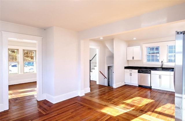 kitchen with stainless steel appliances, sink, white cabinets, and dark hardwood / wood-style floors