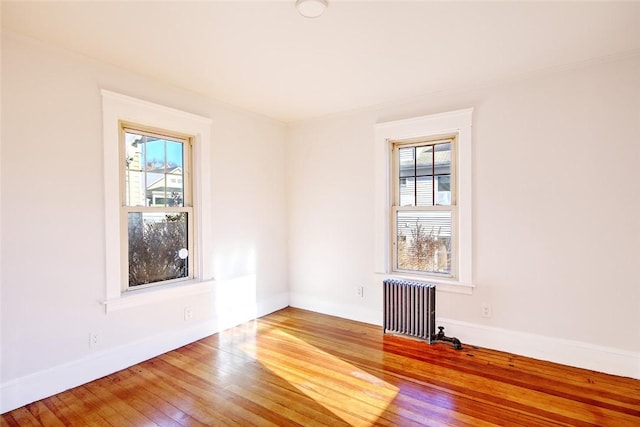 spare room with hardwood / wood-style flooring and radiator