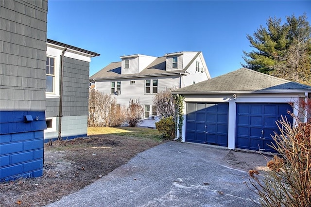 view of front of home featuring a garage and an outbuilding