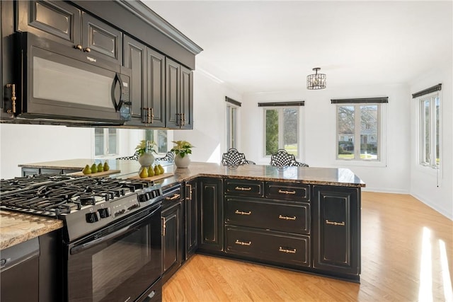 kitchen with stone counters, range with gas stovetop, light wood-type flooring, and kitchen peninsula