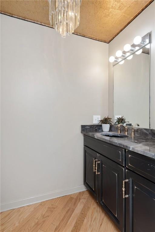 bathroom featuring vanity, hardwood / wood-style floors, and a chandelier