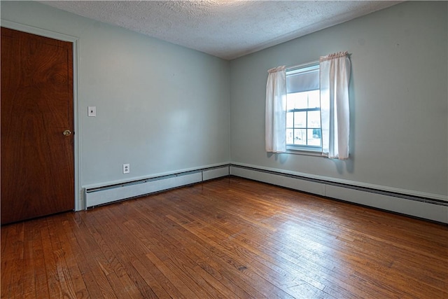 unfurnished room with hardwood / wood-style floors, a baseboard radiator, and a textured ceiling