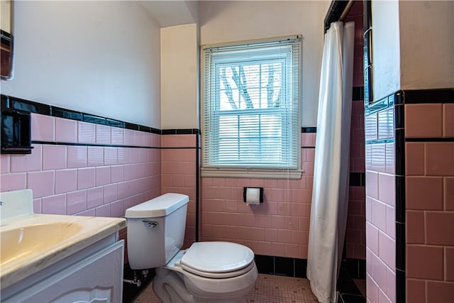 bathroom featuring vanity, tile patterned floors, tile walls, and toilet