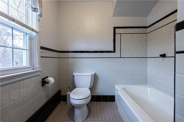 bathroom featuring tile patterned flooring, tile walls, a bathtub, and toilet