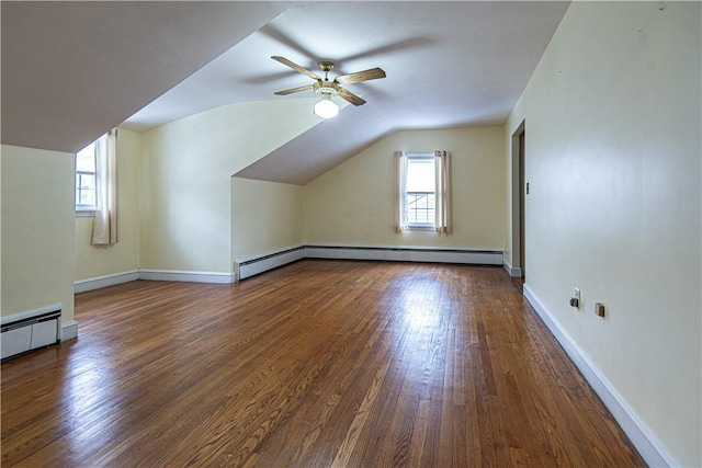 bonus room with lofted ceiling, ceiling fan, dark wood-type flooring, and a healthy amount of sunlight