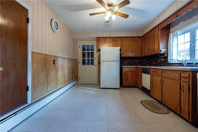 kitchen with a baseboard radiator, sink, light tile patterned floors, ceiling fan, and white appliances