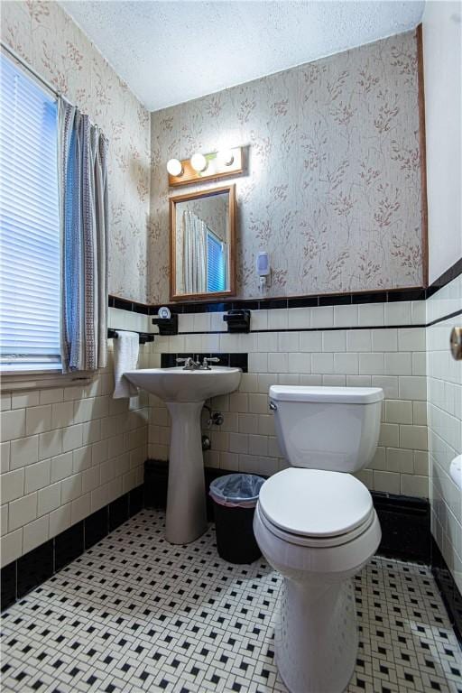 bathroom featuring tile patterned floors, toilet, and a textured ceiling