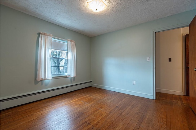 unfurnished room with wood-type flooring, a textured ceiling, and baseboard heating