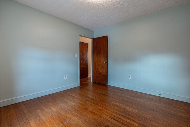 spare room featuring hardwood / wood-style floors and a textured ceiling