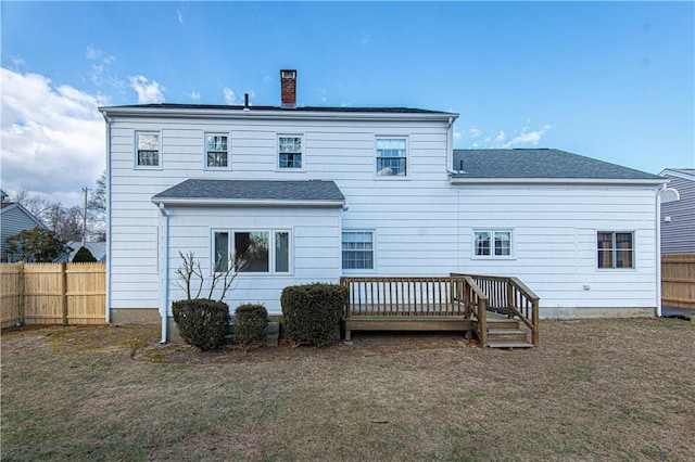 rear view of property featuring a deck and a lawn