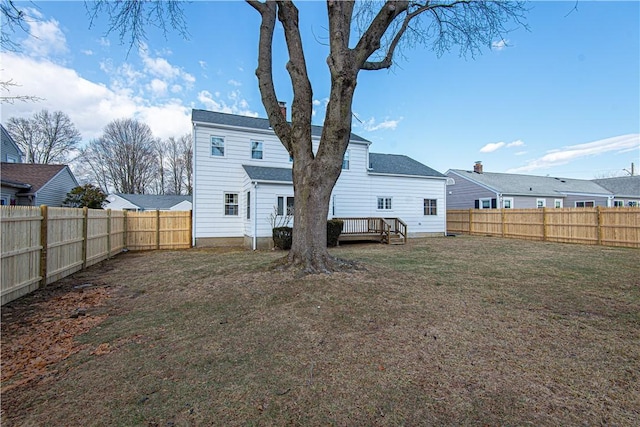 rear view of property with a wooden deck and a yard