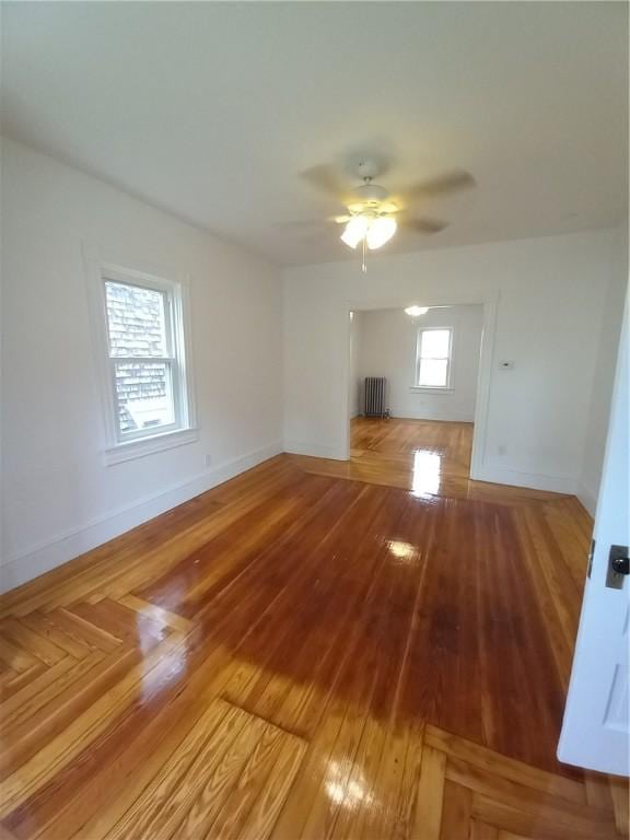 unfurnished living room featuring ceiling fan and radiator