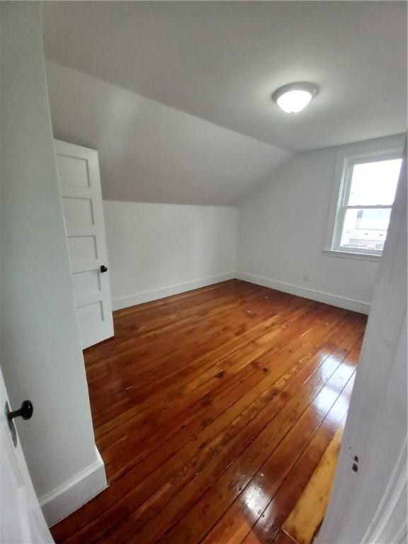 additional living space with lofted ceiling and dark hardwood / wood-style flooring