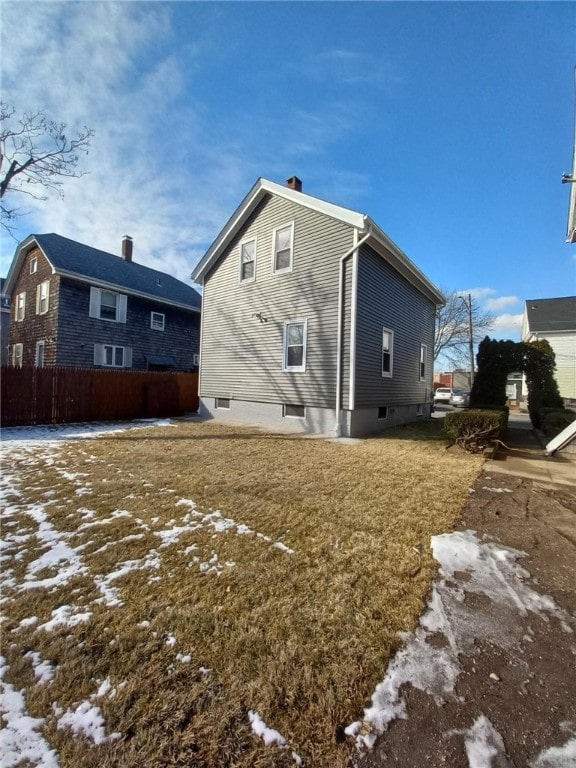 snow covered rear of property with a lawn