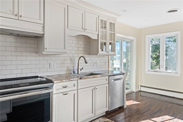 kitchen featuring sink, white cabinets, a baseboard heating unit, light stone counters, and stainless steel appliances