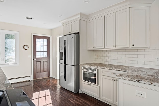 kitchen featuring stainless steel appliances, light stone countertops, a baseboard heating unit, and white cabinets