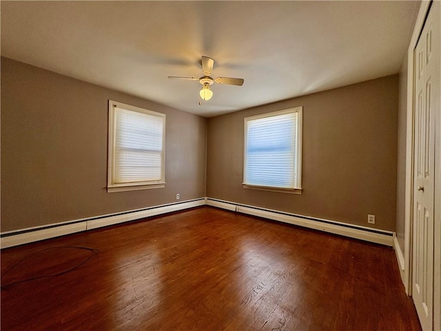 spare room featuring baseboard heating, ceiling fan, and wood-type flooring