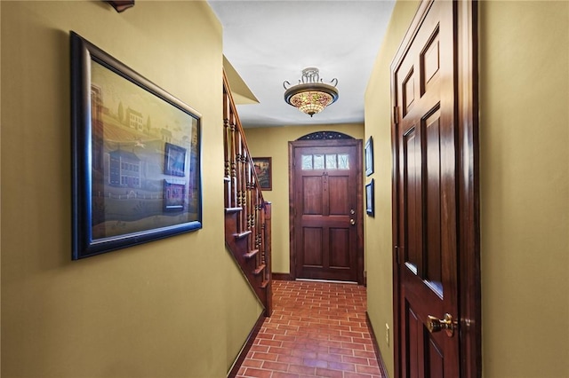 doorway to outside featuring stairway and brick floor